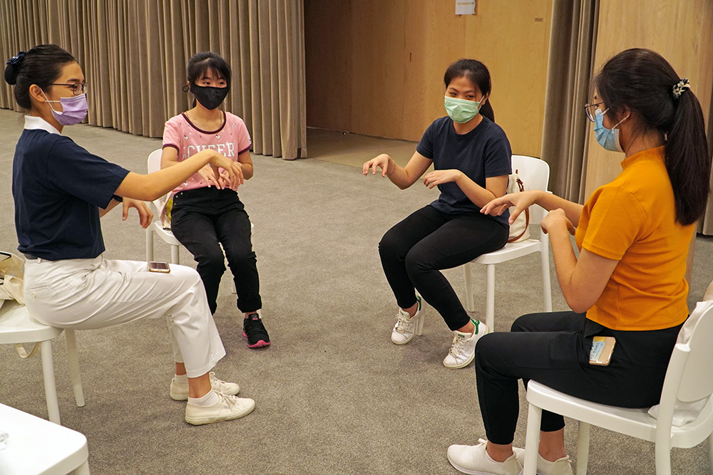 The team form a circle to practice the sign language to ensure synchronicity. (Photo by Chloe Wong)  